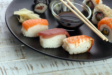close up of sashimi sushi set with chopsticks and soy - sushi roll with salmon and sushi roll with...