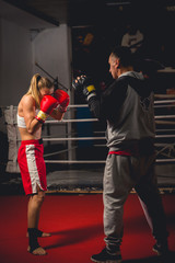 Girl Training on mitts with her boxing instructor