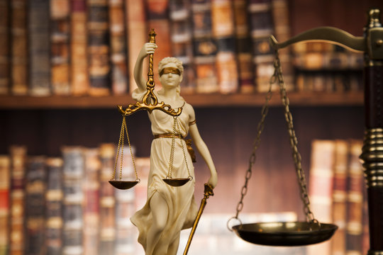 Antique statue of justice, law, books background