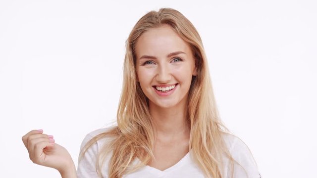 Young beautiful Caucasian blonde girl flirting shying waving and covering mouth with hand on white background