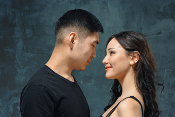 Portrait of smiling Korean couple on a gray