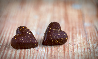 Nahufnahme von Schokoladenherzen auf Holzuntergrund zum Valentinstag