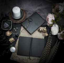 Vintage table with paper, flowers, old watch and candle