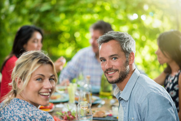 A man lunching with friends on a terrace table