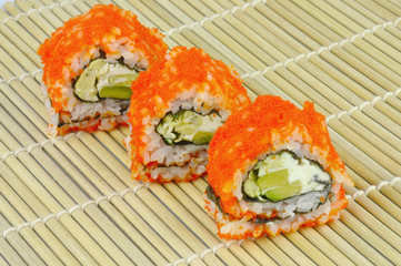 Sushi rolls vegetarian - avocado, cream cheese, omelette, masago roe - on bamboo mat
