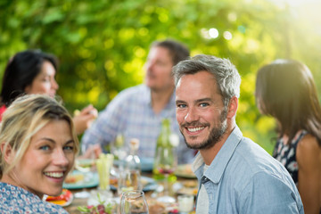 A man lunching with friends on a terrace table