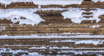 Stacked wooden boards covered with snow