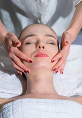 Obraz na płótnie Canvas Girl lies in the spa - salon, she makes a facial massage