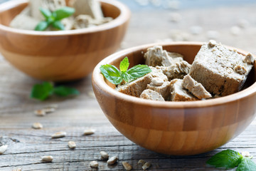 Halva of sunflower seeds and mint in a wooden bowl.