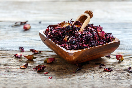 Fototapeta Petals of hibiscus tea in a wooden bowl.