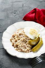 Corned beef with potato, fried egg and pickled cucumbers