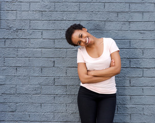 beautiful young black woman laughing against gray wall