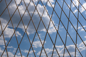 Blue sky with clouds behind metal lattice.