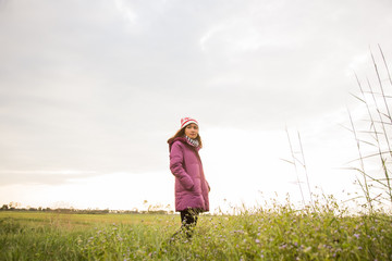 Young woman was playing in a field of flowers in the winter air.