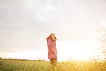 Young woman was playing in a field of flowers in the winter air.