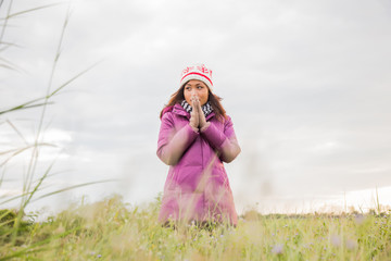 Young woman was playing in a field of flowers in the winter air.