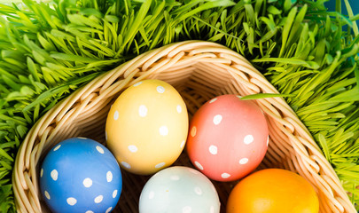Fototapeta na wymiar Easter eggs in basket on meadow