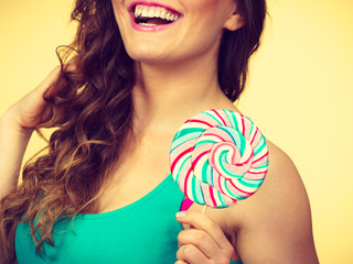 Woman charming girl with lollipop candy