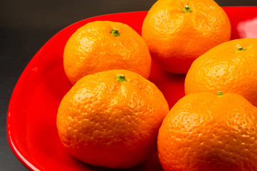 tangerines in a red plate