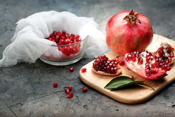 Pomegranate fruits with grains and leaves on the table. Make juice.
