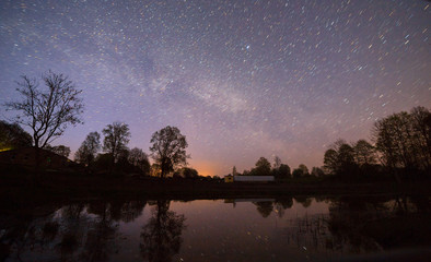 Obraz na płótnie Canvas Night view of starry sky near small river.