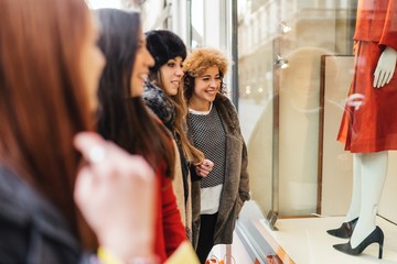 Happy female group of friends doing shopping together