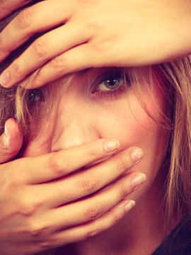 Ashamed embarrassed blonde woman with hands on face