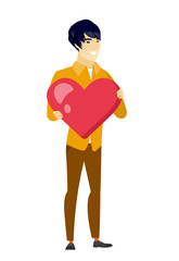 Asian business man holding a big red heart.