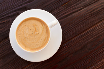 White porcelain cup of coffee on wooden table textural