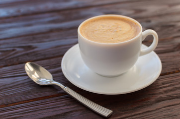 White porcelain cup of coffee on wooden table textural