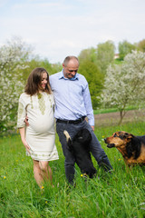 pregnant woman with husband  in blooming garden