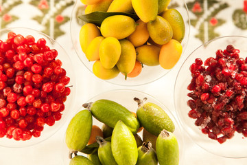 Fresh fruits perfect source of vitamins. Pomegranate, feijoa, red berry and kumquat healthy food for all seasons of the year.