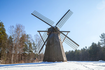 Antique wooden windmill. Winter contryside scene.