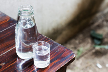 Drinking water in glass and bottle on a wooden floor.