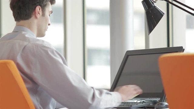 frustrated young business man working on laptop computer at office