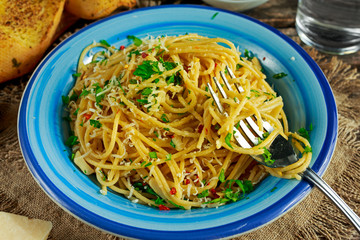 Vegetarian Italian Pasta Spaghetti Aglio E Olio with garlic bread, red chili flake, parsley, parmesan cheese and glas of water