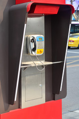 A vintage pay phone on a street side
