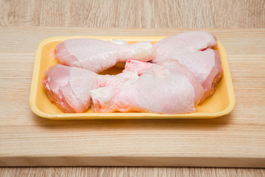 Chicken meat in the plate on the wooden board in the kitchen. Cooking at home. Healthy eating and lifestyle. 