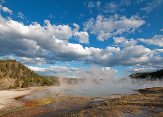Excelsior Geyser under afternoon cloudscape  in the Midway Geyser Basin next to the Firehole River in Yellowstone National Park in Wyoming USA