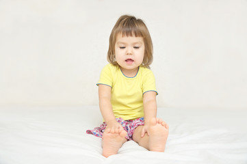 Fototapeta premium Little girl sitting on bed