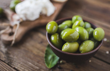Green olives, sliced ciabatta, feta cheese on a wooden board. Spice. Garlic. Chees Feta. Ciabatta. Olives on a wooden background. Copyspace