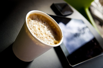Coffee, tablet and mobile phone on a table