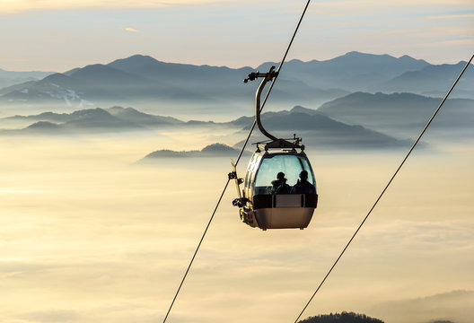 Sight on the cable-way infrastructure over foggy valley. Ropeway and cablecar transport system for skiers