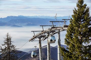 Ski lift cable booth or car, Ropeway and cableway transport sistem for skiers with fog on valley background