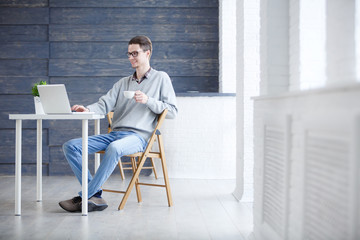 Portrait of young businessman in office with big window.