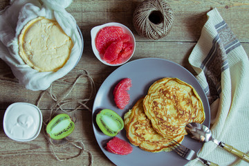 Pancakes on a large gray plate, fruit and dairy products. Country style
