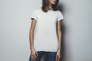 Young pretty girl wearing blank white t-shirt with space for your logo or design, mock-up of white...