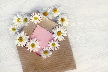 flower message for lovers/ heart symbol of daisies comes from an open letter paper, top view