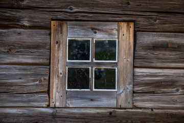 Obraz na płótnie Canvas Square window of old one-storey wooden house in the North