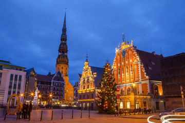 Fototapeta premium Illuminated City Hall Square with House of the Blackheads and Saint Peter church in Old Town